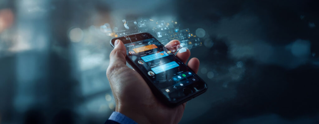 Pessoa segurando um smartphone com tela de mensagens abertas, representando atendimento digital e comunicação via aplicativos.