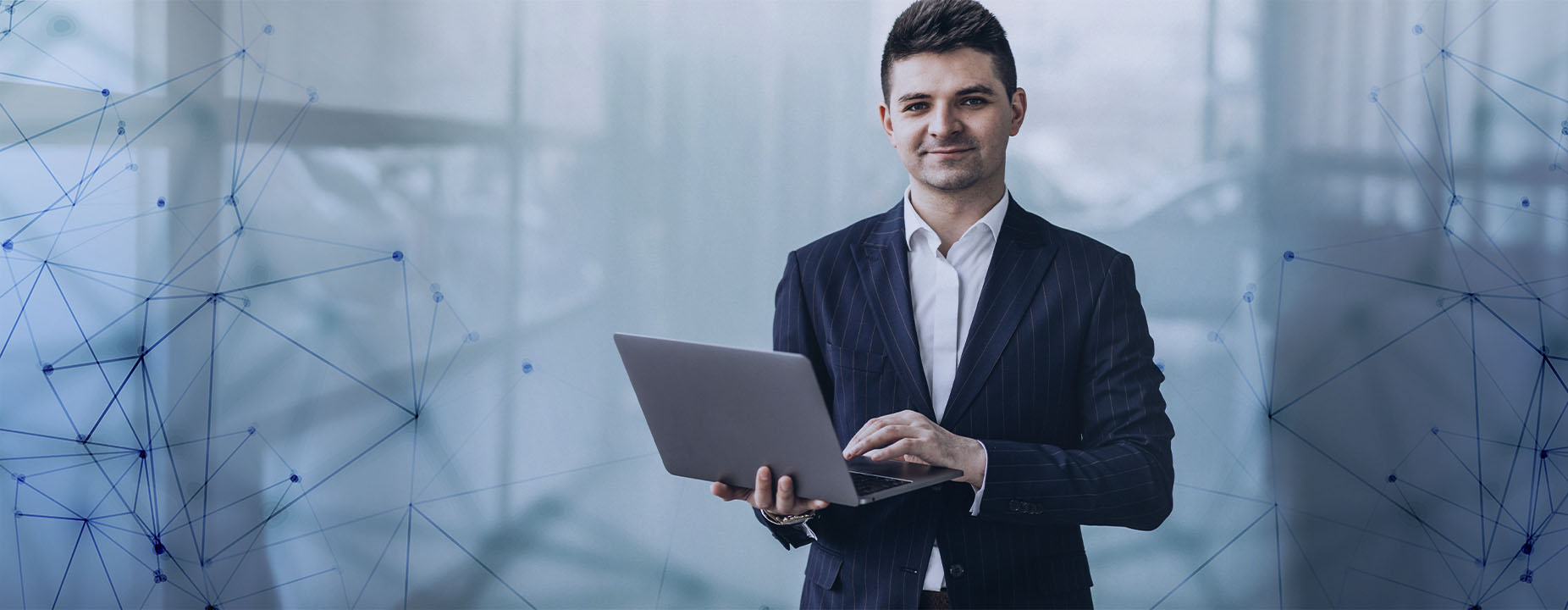 Homem jovem usando terno e segurando um laptop, em um ambiente corporativo, com elementos gráficos conectando pontos, simbolizando tecnologia.